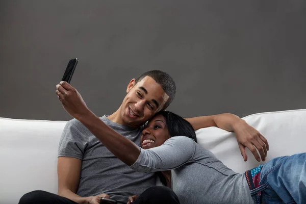 Hombre joven y una mujer usando teléfonos móviles — Foto de Stock