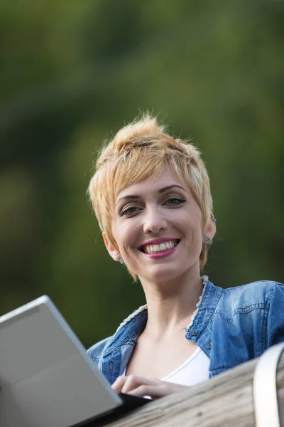 Woman using a laptop tablet outdoors — Stock Photo, Image