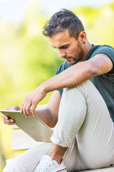 Yakışıklı adam açık havada bir tablet ile — Stok fotoğraf