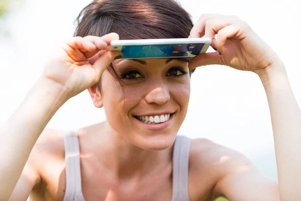 Mulher sorrindo e protegendo do sol — Fotografia de Stock