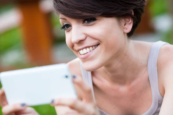 Mujer disfrutando algo en la pantalla de su móvil — Foto de Stock