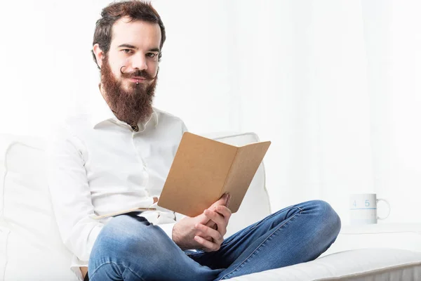 Ontspannen student lezen in zijn woonkamer — Stockfoto