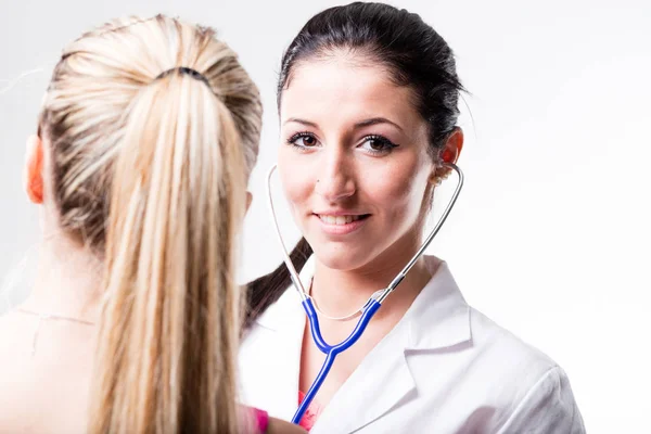 Rücken einer Patientin vor ihrem Arzt — Stockfoto