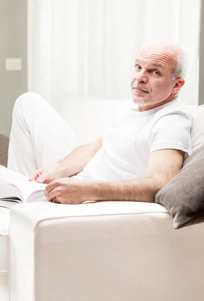 Man lezen van een boek in zijn woonkamer — Stockfoto