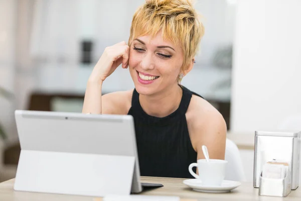 Vrouw die lacht naar een computerscherm — Stockfoto