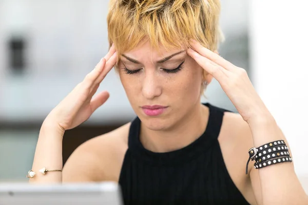Working overtime a woman has a headache — Stock Photo, Image