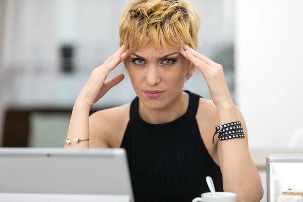 Working overtime a woman has a headache — Stock Photo, Image