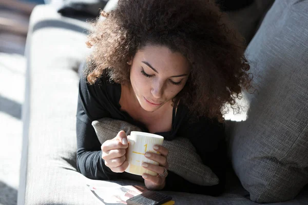 Одинокая молодая женщина наслаждается чашкой кофе — стоковое фото