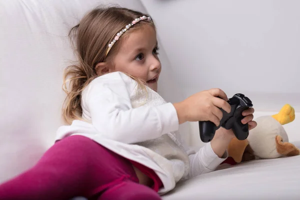 Niña jugando con un controlador de videojuegos — Foto de Stock