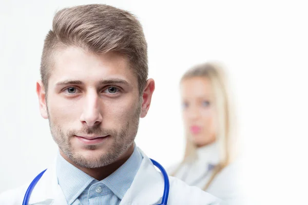 Doctor con estetoscopio alrededor del cuello sonriendo a la cámara — Foto de Stock