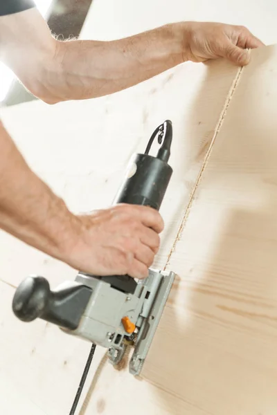 Amrs of a woodworker cutting a plank — Stock Photo, Image