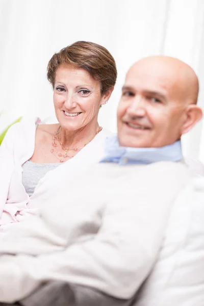 Feliz casal de meia-idade relaxante em casa — Fotografia de Stock