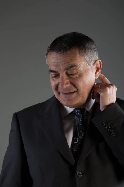 Thoughtful businessman scratching his ear — Stock Photo, Image