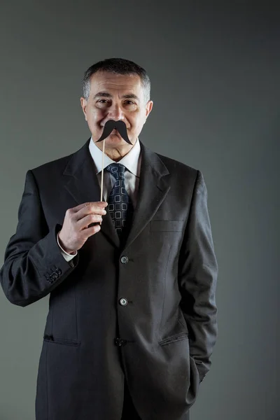 Homme d'affaires souriant tenant une moustache — Photo