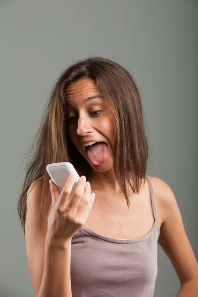 Långbent ung kvinna sticker ut tungan — Stockfoto