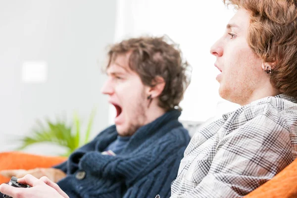 Dos hermanos jugando videojuegos en casa — Foto de Stock