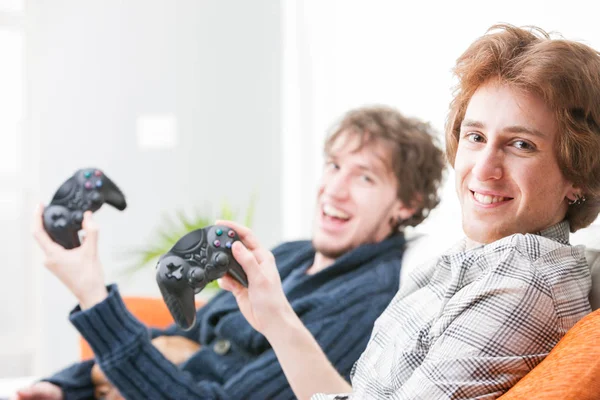 Dos hermanos adolescentes sonrientes sosteniendo joysticks — Foto de Stock