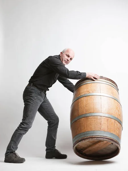 Man moving a large oak wine or beer barrel — Stock Photo, Image