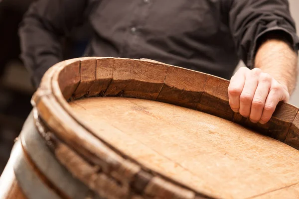 Man standing with his hand on an oak barrel — Stock Photo, Image