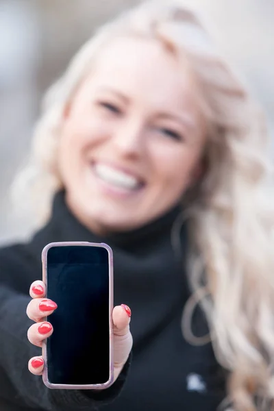 Woman showing mobile phone outdoors — Stock Photo, Image