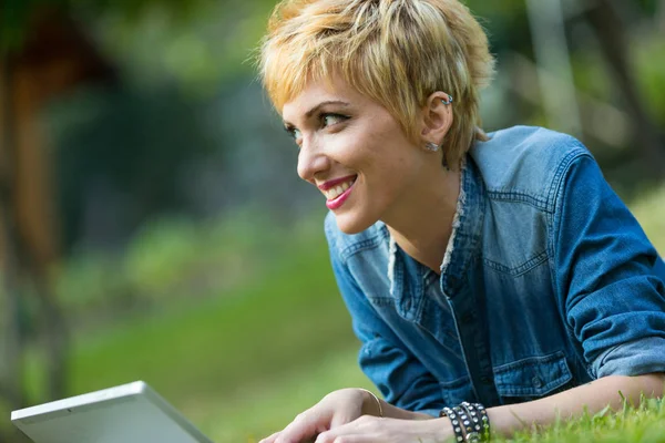 Mulher sorrindo surfar na internet ao ar livre — Fotografia de Stock