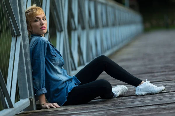 Posa casual ma sensuale su un ponte di legno — Foto Stock