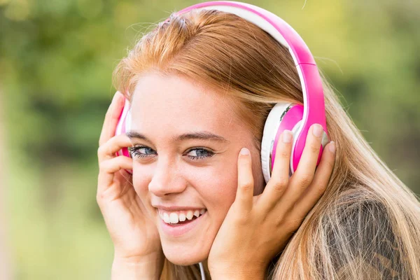 Bonita chica con auriculares rosados — Foto de Stock