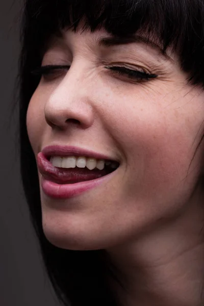 Portrait of a winling woman with little tongue stuck out — Stock Photo, Image