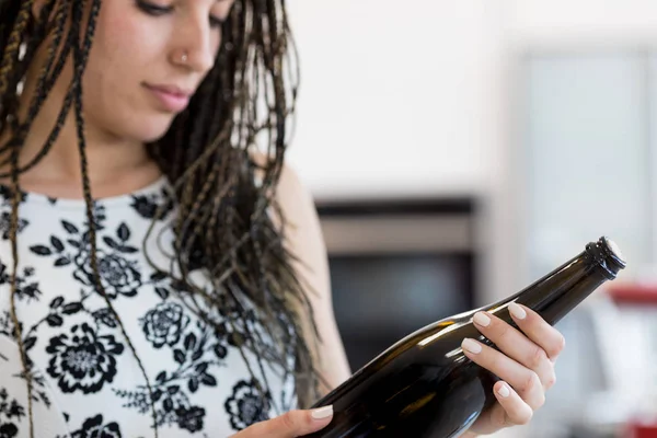 Young woman looking at bottle — Stock Photo, Image