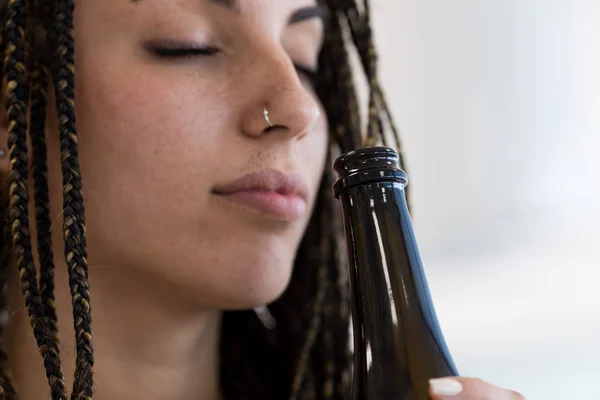 Close-up of woman smells bottle — Stock Photo, Image