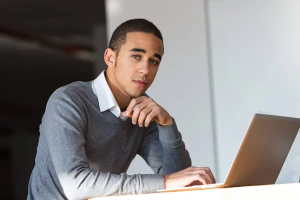Zamyšlený mladý podnikatel na laptop — Stock fotografie
