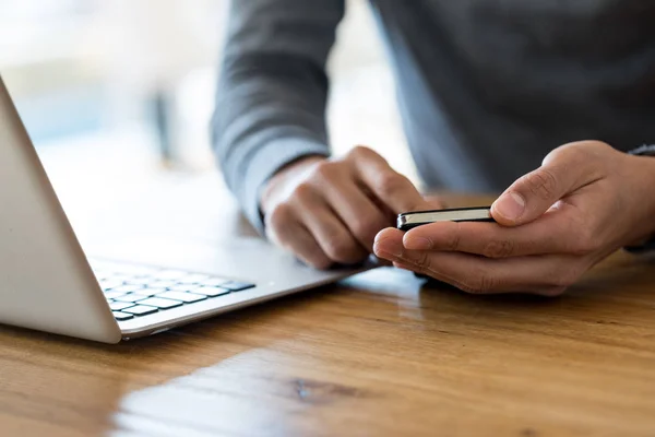 Cropped of man holding cell phone at working place — Stock Photo, Image