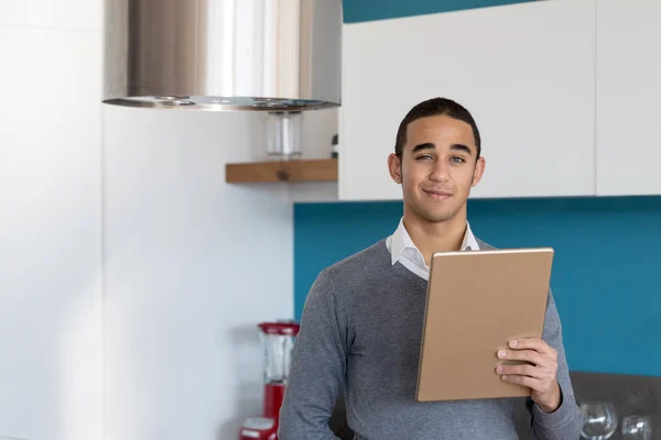 Man with gold tablet winking to camera — Stock Photo, Image