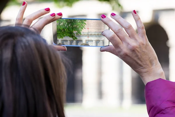 Femme dans une ville prendre des photos avec téléphone transparent — Photo