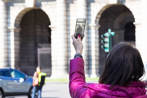 Mujer en una ciudad tomando fotografías con teléfono transparente — Foto de Stock