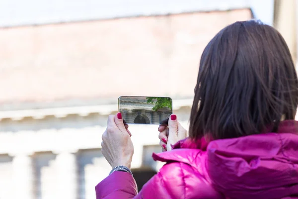 Mujer en una ciudad tomando fotografías con teléfono transparente — Foto de Stock