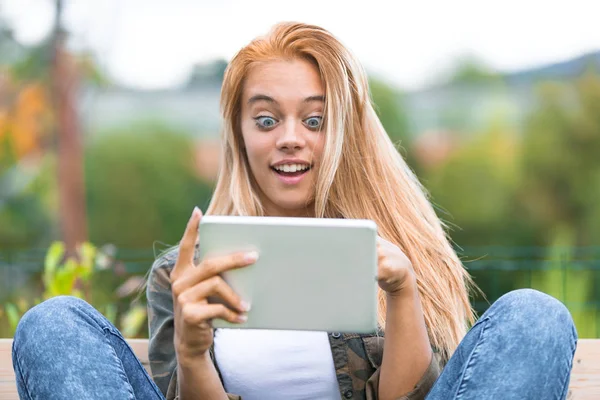 Caras engraçadas f uma menina chocada e um tablet — Fotografia de Stock