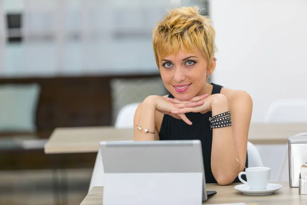 Smiling businesswoman sat at desk with computer — Stock Photo, Image