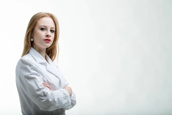 Thoughtful young female doctor with folded arms — Stock Photo, Image