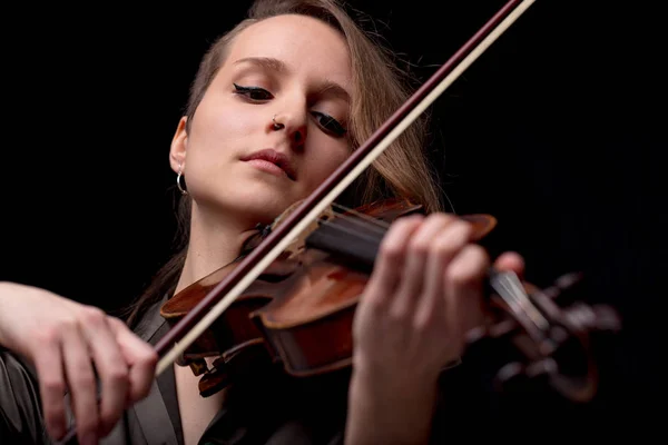 真面目なかわいい女性が黒でバイオリンを弾く — ストック写真