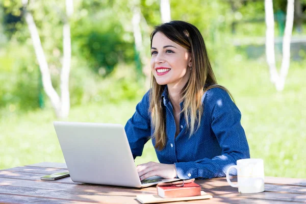 Een mooie gelukkige vrouw met laptop buiten — Stockfoto