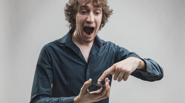 Man geamuseerd door zijn smartphone-functies — Stockfoto