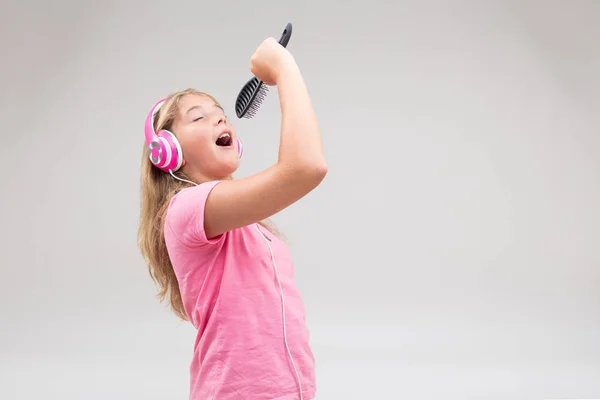 Dziewczyna z słuchawki udając piosenkarka — Zdjęcie stockowe