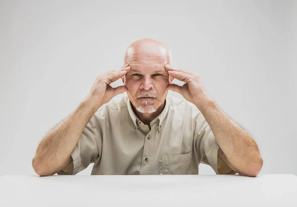 Fundersam senior mannen med en fokuserad uttryck — Stockfoto