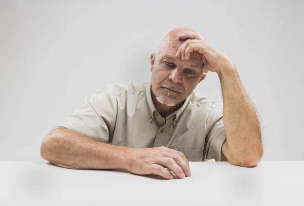 Homme âgé découragé assis en pensant — Photo