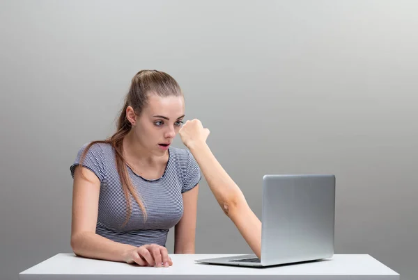 Mulher assustada por um braço estendendo-se do computador portátil — Fotografia de Stock