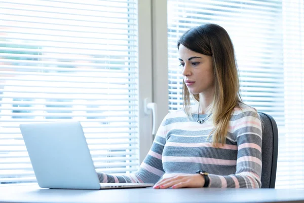 Jonge vrouw zitten in de voorkant van laptop — Stockfoto