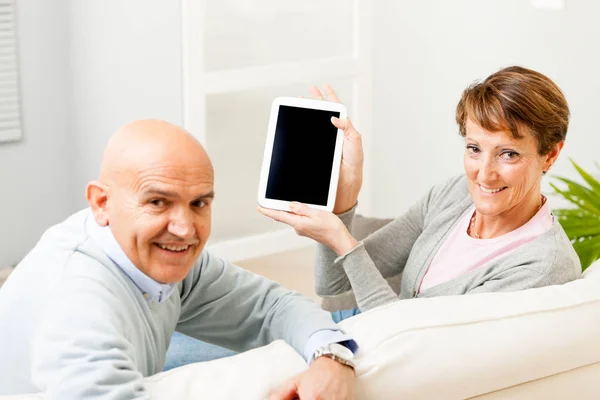 Mature couple displaying a blank tablet-pc — Stock Photo, Image