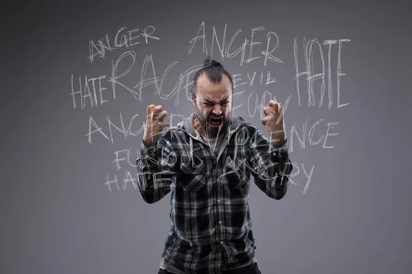 怒れる男が復讐に燃える怒り叫び 憎しみ 怒りの周りの回転彼の後ろの黒板に単語のタグクラウドと彼の拳で空気を Clawing のフィット — ストック写真