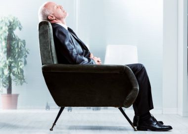 Tired businessman taking a moment to relax clipart